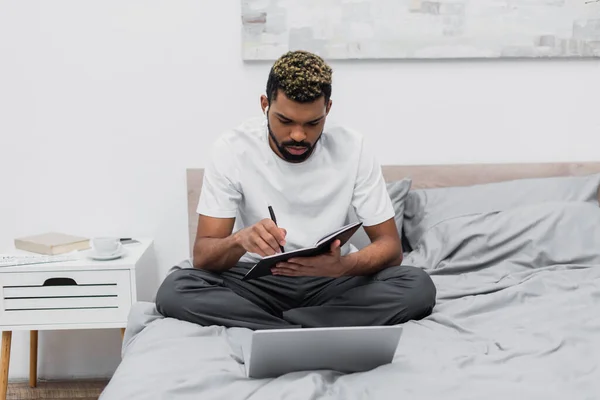 Bearded African American Man Wireless Earphones Looking Notebook Laptop Bed — Stock Photo, Image