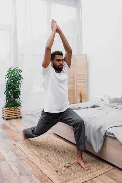 Hombre Afroamericano Barbudo Practicando Yoga Pose Guerrera Meditando Dormitorio Moderno —  Fotos de Stock
