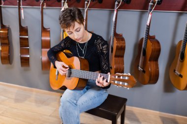 Musician playing acoustic guitar in music store 