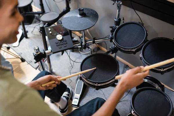stock image Blurred african american customer playing electronic drums in music store 