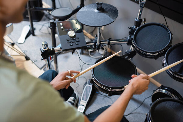 Cropped view of african american customer playing electronic drums in music shop 