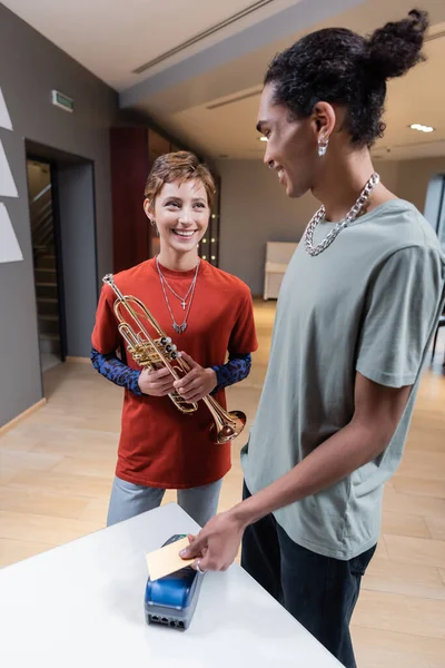 Smiling African American Man Paying Credit Card Girlfriend Trumpet Music — Stockfoto