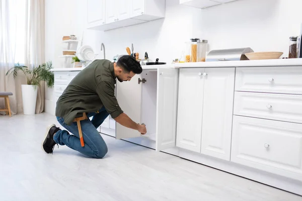 Side View Muslim Man Tool Belt Fixing Kitchen Cabinet — Zdjęcie stockowe