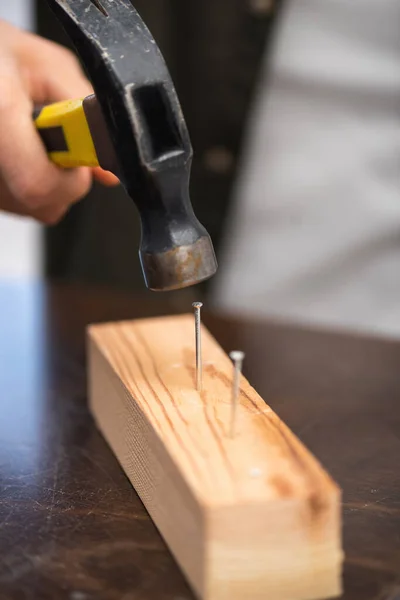 Cropped View Handyman Holding Blurred Hammer Nails Wooden Board — Zdjęcie stockowe