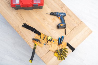 Top view of tool belt near gloves on table 