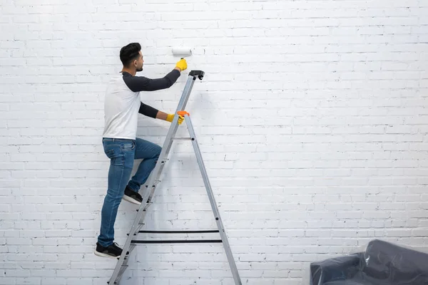 Arabian Man Gloves Coloring Wall While Standing Ladder Home — Foto de Stock
