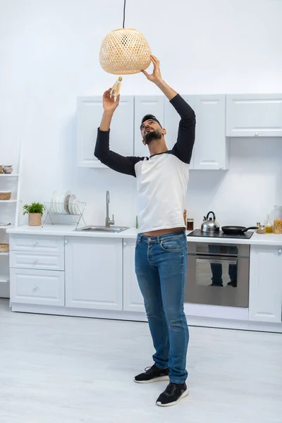Arabian Man Holding Lightbulb Chandelier Kitchen — Foto de Stock