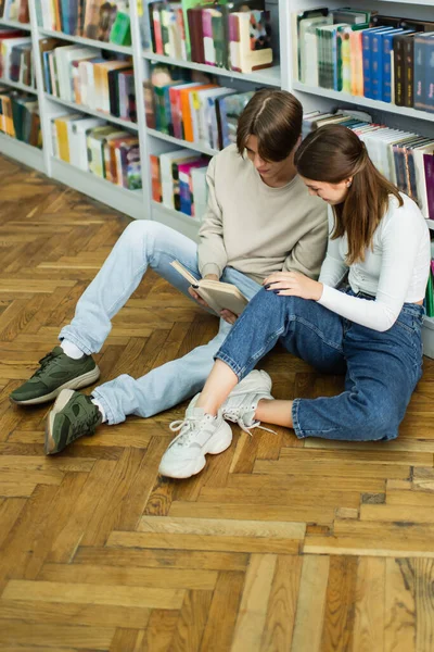 Full Length Teenage Friends Sitting Floor Library Reading Book — Foto de Stock
