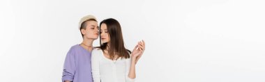 pretty lesbians in stylish casual clothes holding hands isolated on grey, banner