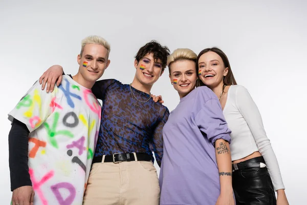 low angle view of lgbtq community friends smiling at camera isolated on grey