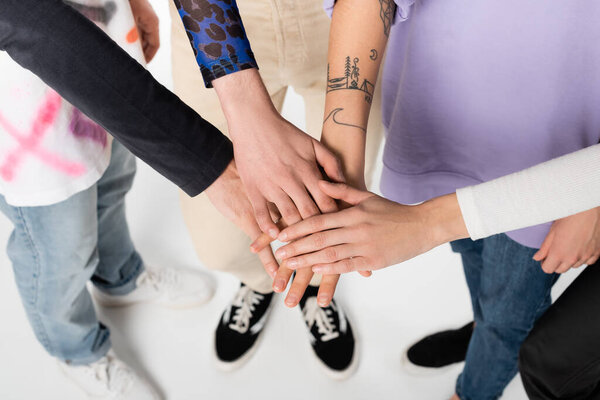 top view of cropped lgbtq community people joining hands on white background