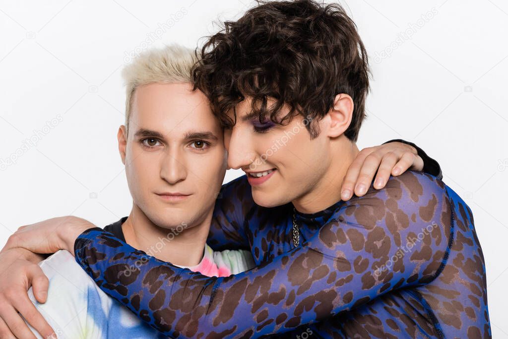brunette queer person embracing blonde gay man isolated on grey