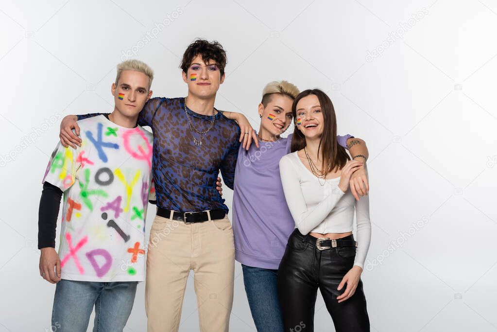 young lgbtq community friends looking at camera while embracing isolated on grey