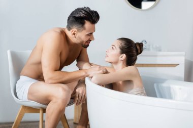 İç çamaşırlı üstsüz adam evde banyo yapan seksi kız arkadaşına dokunuyor.