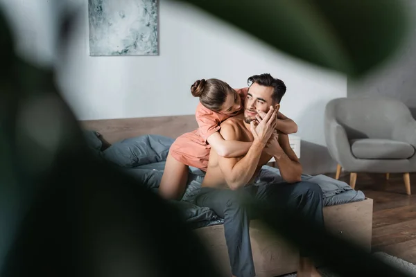 Seductive Woman Hugging Shirtless Man Sitting Bed Pajama Pants Blurred — Stock Photo, Image