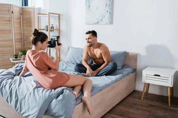 Smiling Shirtless Man Pajama Pants Sitting Grey Bedding Girlfriend Vintage — Stock Photo, Image