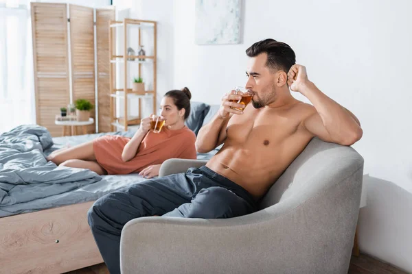 Sexy Shirtless Man Drinking Tea Armchair Blurred Girlfriend Bed — Stock Photo, Image