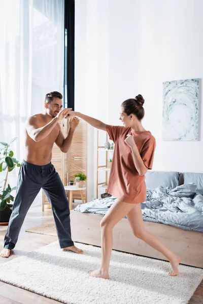 Full Length Cheerful Couple Fighting While Having Fun Bedroom — Stock Photo, Image