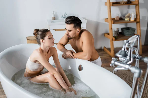 性感的年轻女人在赤身裸体的男朋友旁边洗澡 身体也很强壮 — 图库照片