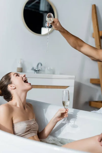 Mann Schüttet Champagner Badewanne Neben Verblüffter Junger Frau — Stockfoto
