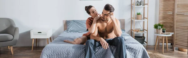 Sexy Hombre Pantalones Pijama Cerca Novia Abrazándolo Cama Casa Pancarta — Foto de Stock