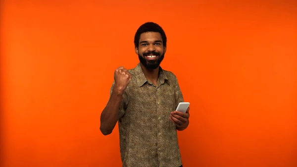 Χαρούμενα Αφρικής Αμερικανός Άνθρωπος Γενειάδα Κρατώντας Smartphone Πορτοκαλί Φόντο — Φωτογραφία Αρχείου