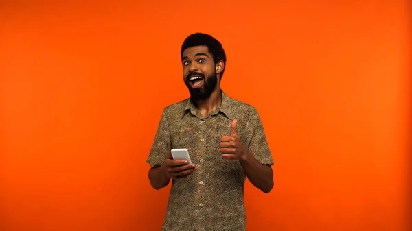 Animado Afro Americano Homem Usando Smartphone Mostrando Como Fundo Laranja — Fotografia de Stock