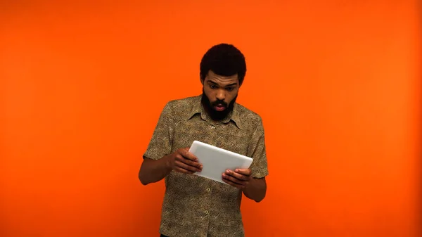 Sorprendido Joven Afroamericano Con Barba Sosteniendo Tableta Digital Sobre Fondo — Foto de Stock