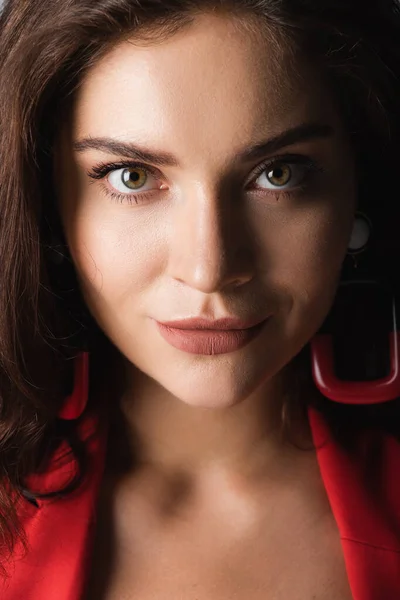 Close up of young woman in red earrings looking at camera — Stock Photo