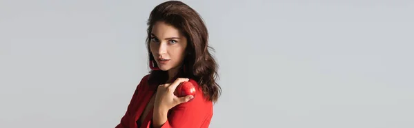 Mulher elegante em terno vermelho posando e segurando maçã isolada em cinza, banner — Fotografia de Stock