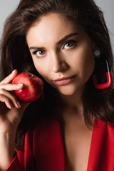 Stylische Frau mit rotem Apfel isoliert auf grau — Stockfoto