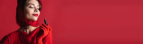 Femme gaie en gant, foulard et béret regardant rouge à lèvres isolé, bannière — Photo de stock