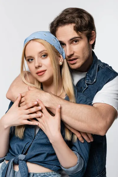 Jeune homme étreignant femme blonde dans le bandeau isolé sur blanc — Photo de stock