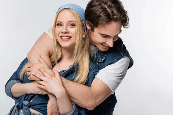 Blonde woman in headband looking at camera near stylish man hugging her isolated on white — Stock Photo