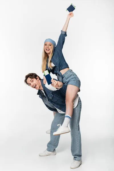 Excited couple with passports and air tickets having fun on white — Stock Photo