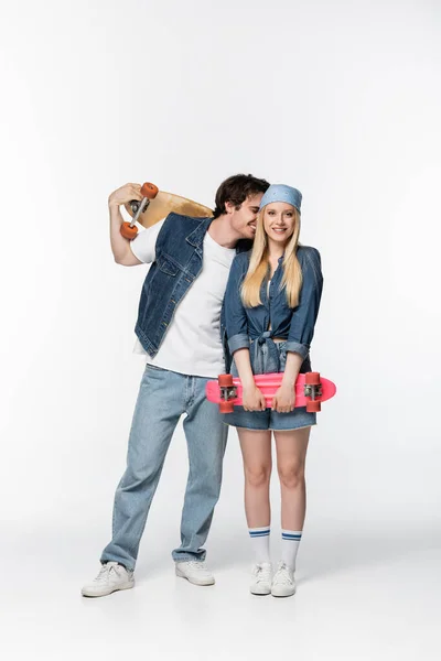 Cheerful woman with penny board near excited man with longboard on white — Stock Photo