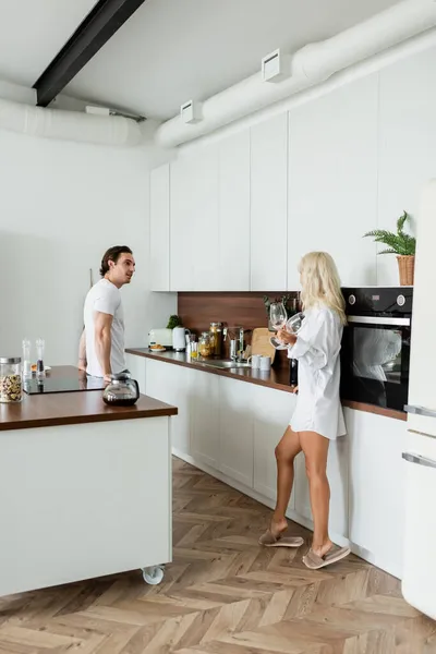 Tattooed man looking at girlfriend with wine glasses — Stock Photo