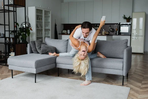 Cheerful couple having fun in living room — Stock Photo