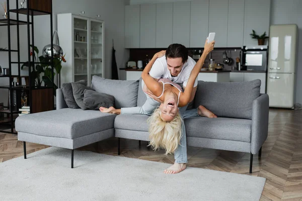 Casal alegre se divertindo na sala de estar — Fotografia de Stock