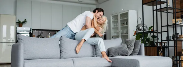 Alegre joven pareja divirtiéndose en sala de estar, pancarta - foto de stock