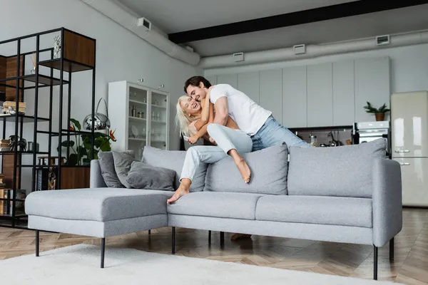 Alegre joven pareja divirtiéndose en moderno salón - foto de stock