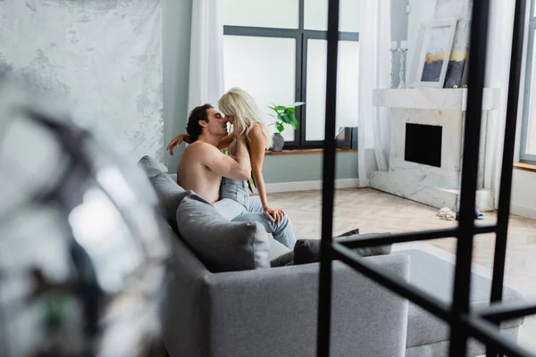 Vue latérale du couple passionné embrassant sur le canapé — Photo de stock