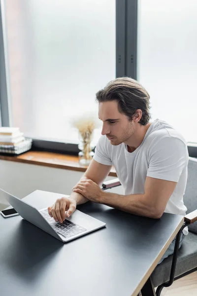 Concentrated freelancer looking at laptop while working from home — Stock Photo