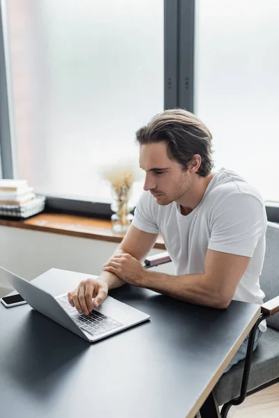 Konzentrierte Freiberuflerin schaut von zu Hause aus auf Laptop — Stockfoto