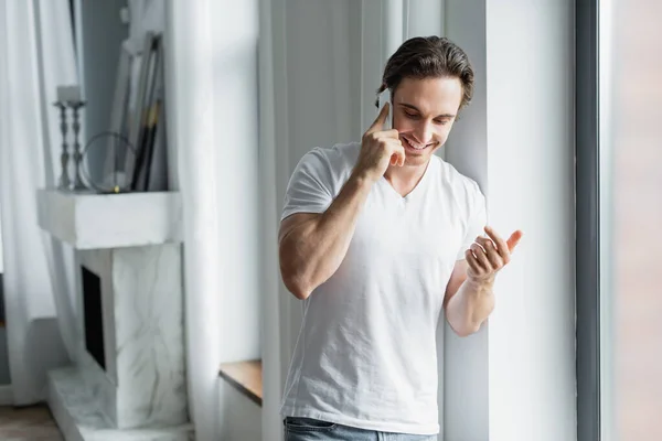 Uomo allegro che parla sul cellulare a casa — Foto stock