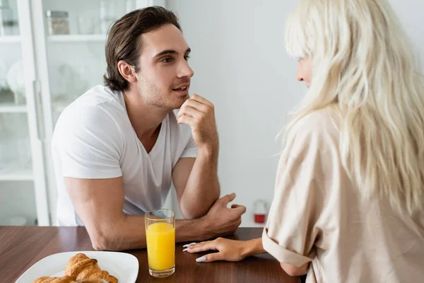 Hombre mirando rubia novia cerca de desayuno en mesa - foto de stock