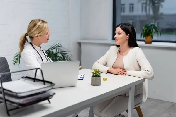 Arzt spricht Schwangere während Konsultation in Klinik an — Stockfoto