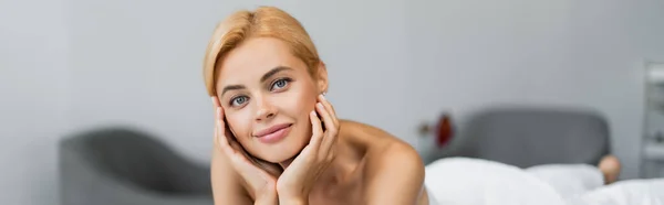 Happy blonde client looking at camera in spa center, banner — Stock Photo