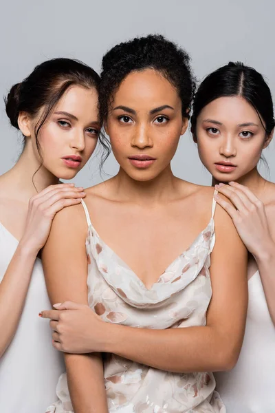 Multiethnic women touching shoulders of african american friend isolated on grey — Stock Photo