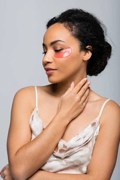 Pretty african american woman with eye patch touching neck isolated on grey — Stock Photo